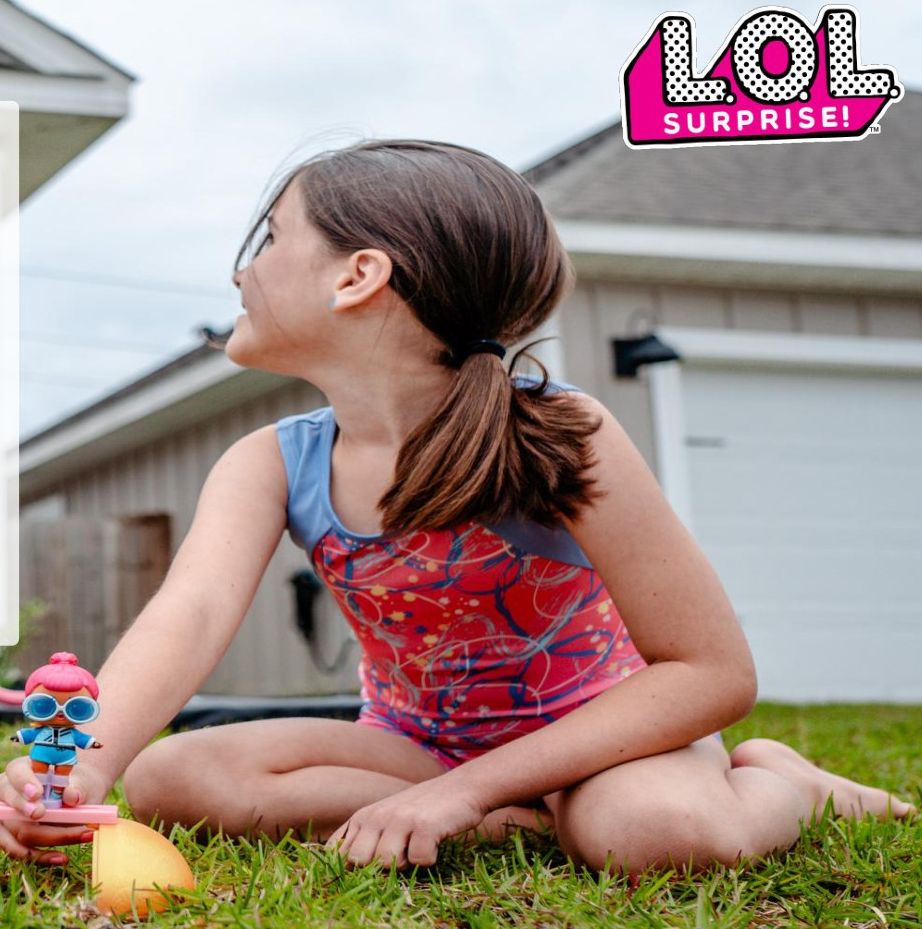 Child playing with genuine L.O.L. Surprise! dolls outdoors